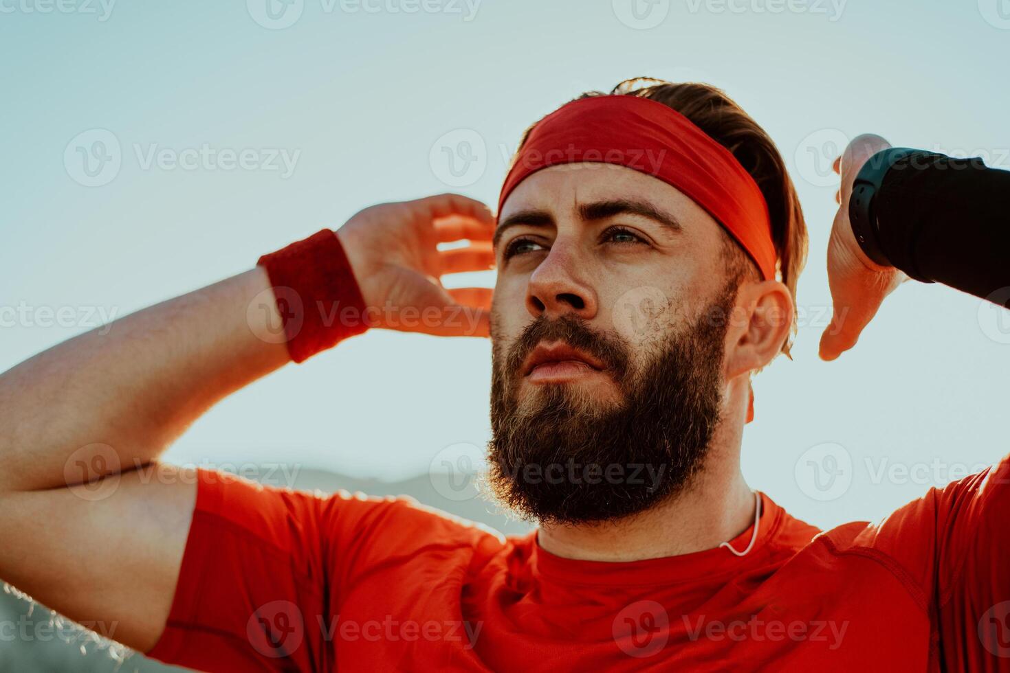 A determined athlete preparing for the start of training on the top of the mountain at sunrise. photo
