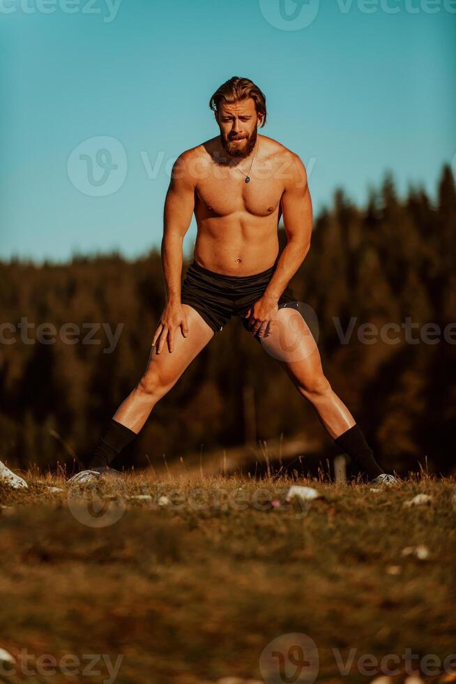A man stretching after a hard workout in the early hours of the morning photo