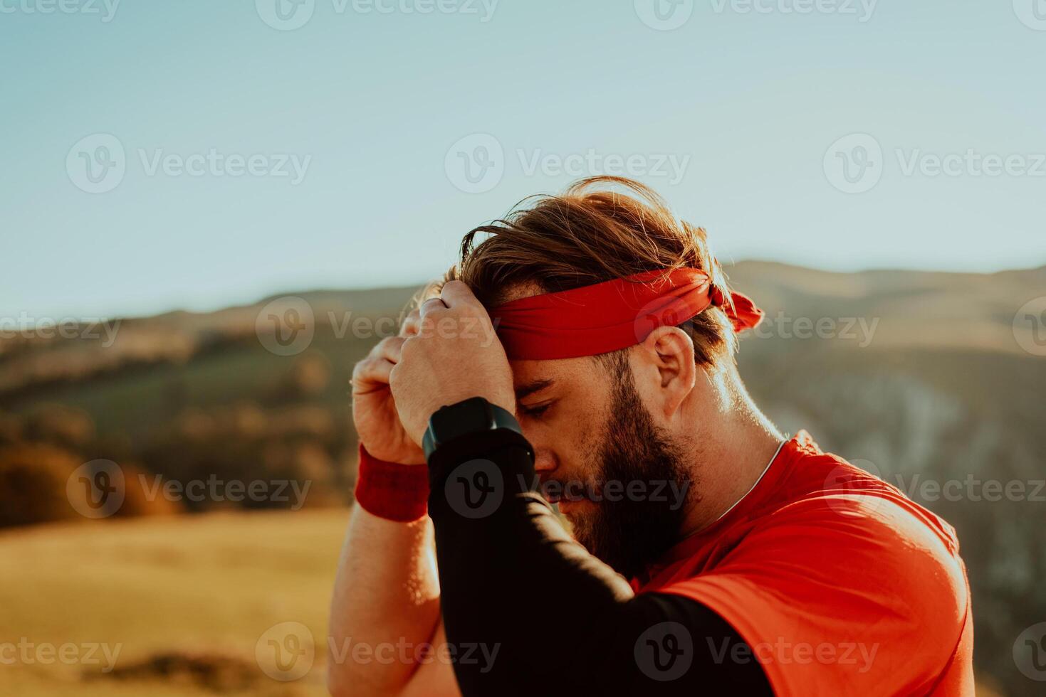 A determined athlete preparing for the start of training on the top of the mountain at sunrise. photo