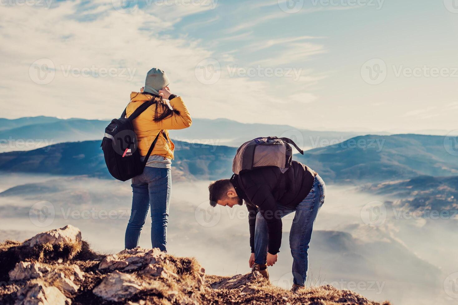 happy couple man and woman tourist at top of mountain during a hike in summer photo