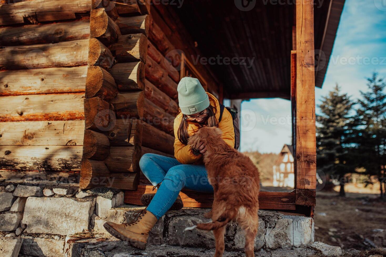 a young beautiful girl is playing with her dog at the cottage photo
