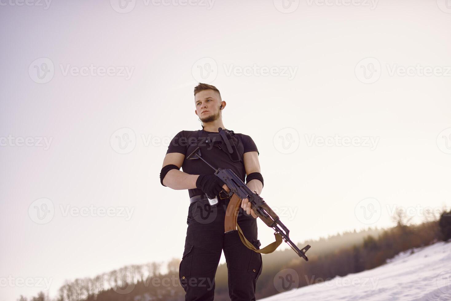 soldier with weapons in forest somewhere above the Arctic Circle photo