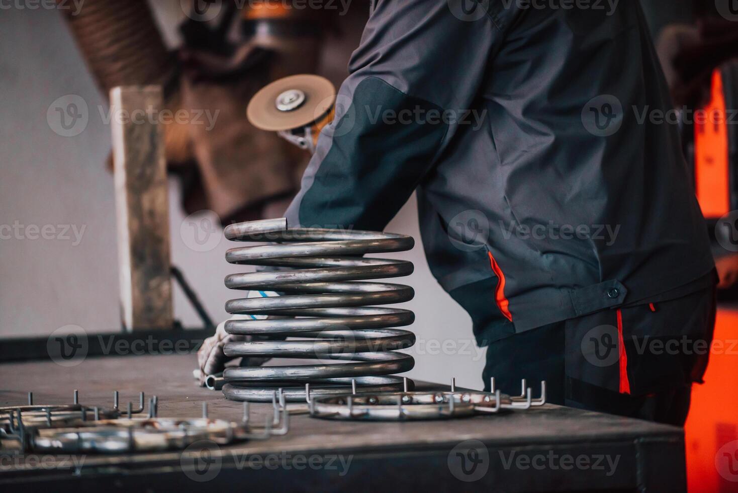 Locksmith in special clothes and goggles works in production. Metal processing with angle grinder. Sparks in metalworking. photo