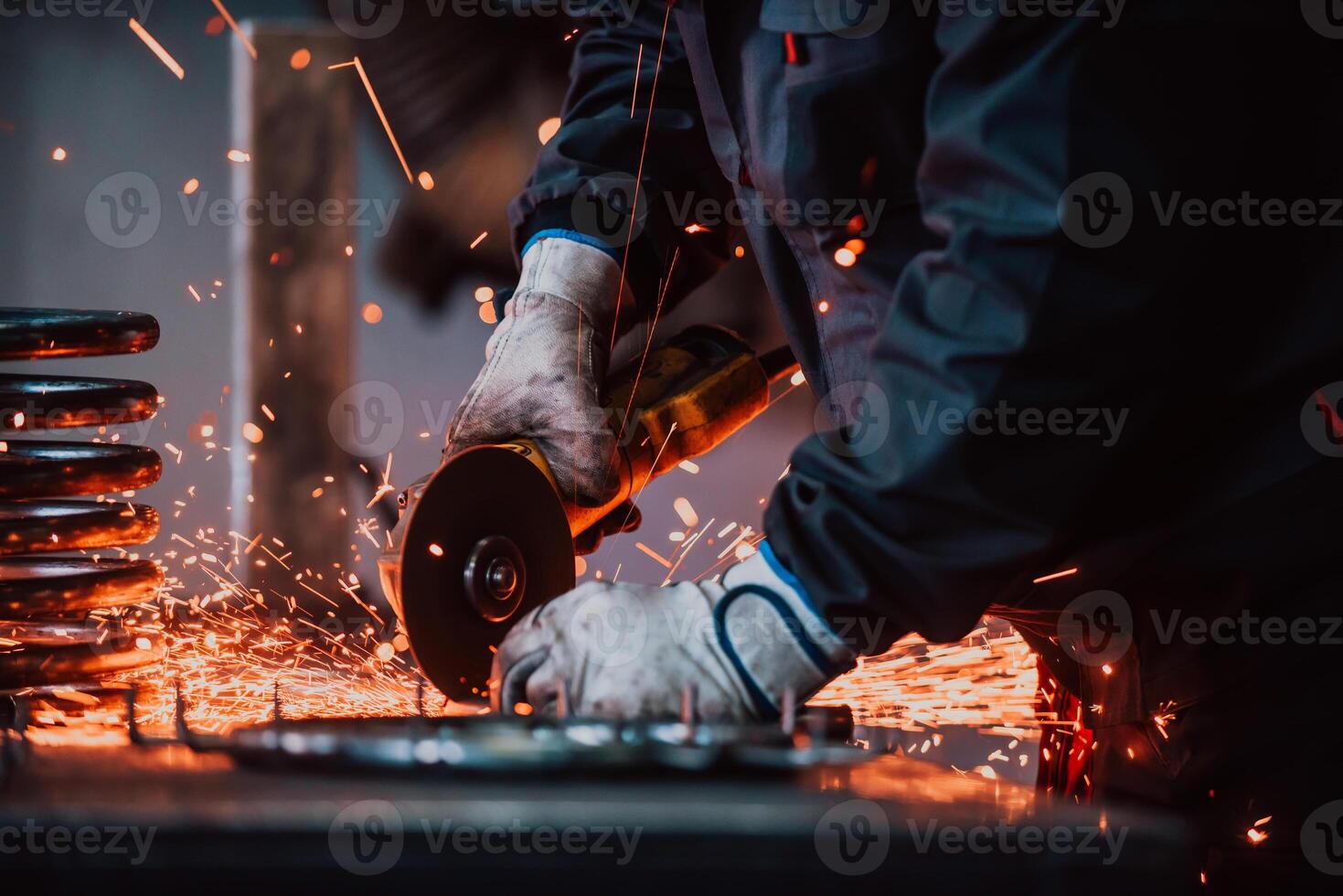 Locksmith in special clothes and goggles works in production. Metal processing with angle grinder. Sparks in metalworking. photo