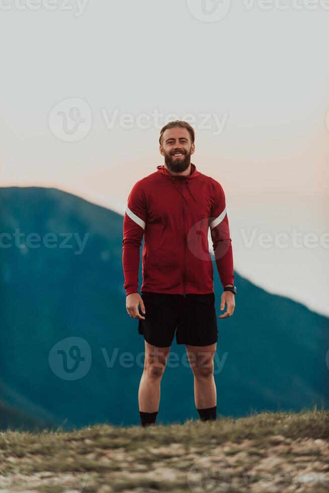 An athlete rests on top of a mountain after exhausting running training. photo