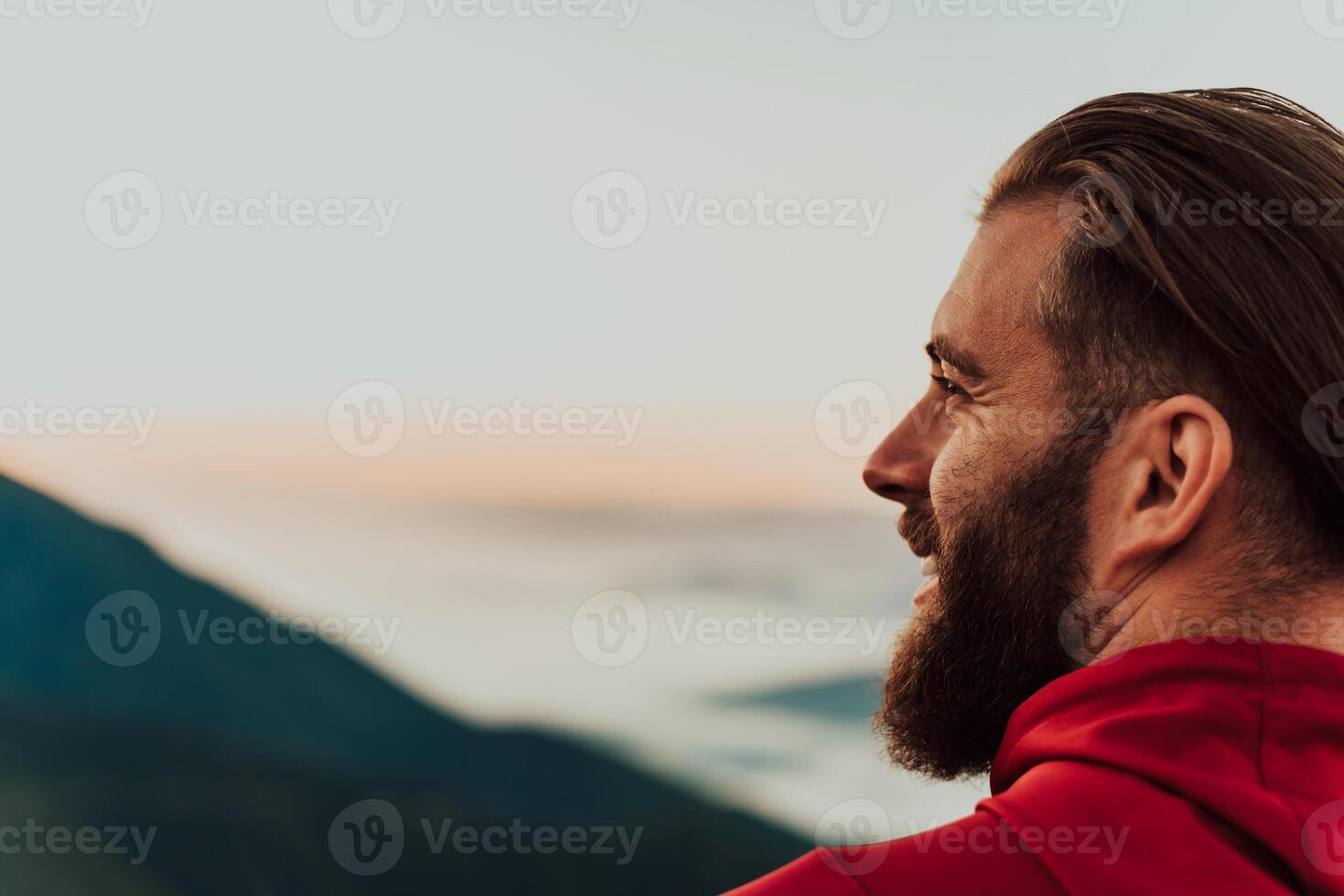 An athlete rests on top of a mountain after exhausting running training. photo