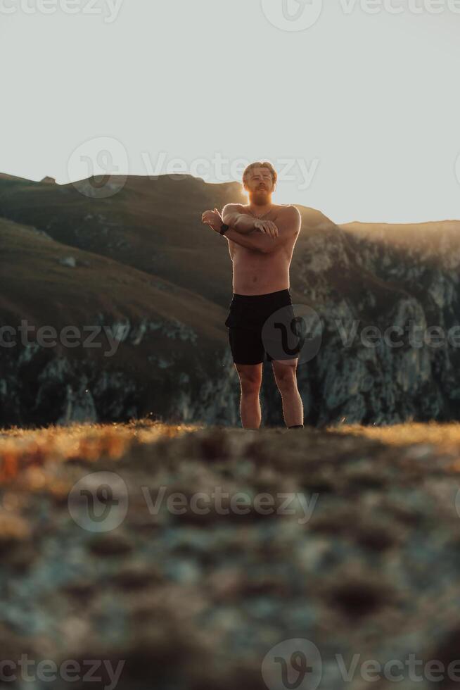 A man stretching his arms after a hard workout in the early hours of the morning photo