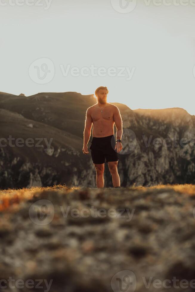 An athlete rests on top of a mountain after exhausting running training. photo
