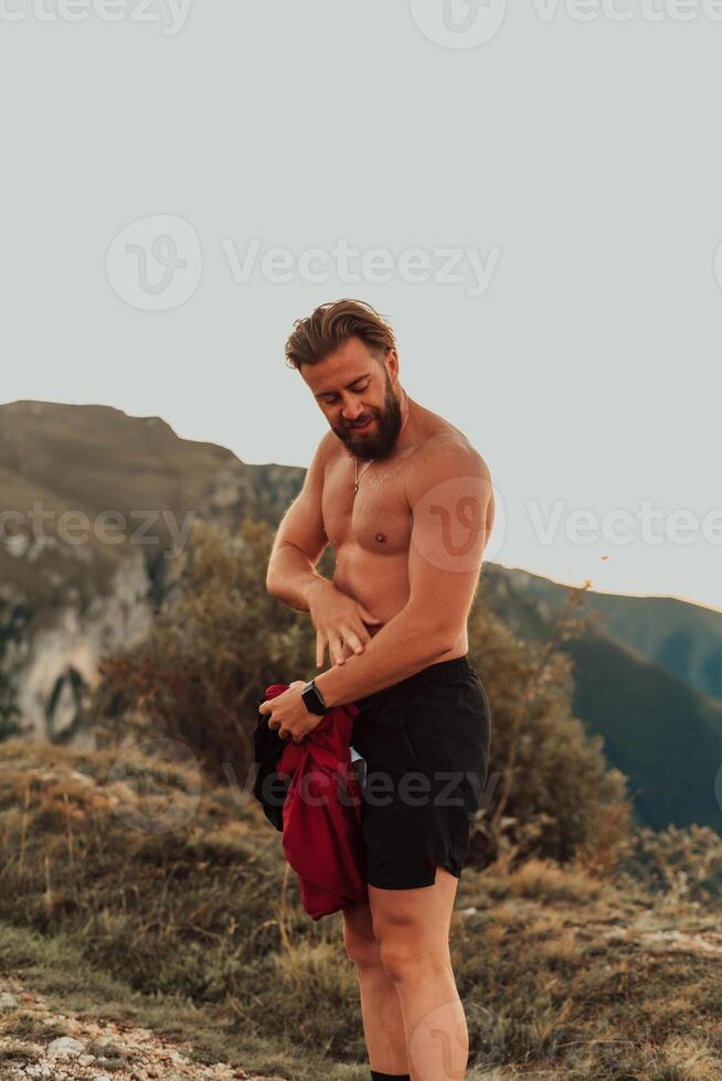 An athlete rests on top of a mountain after exhausting running training. photo