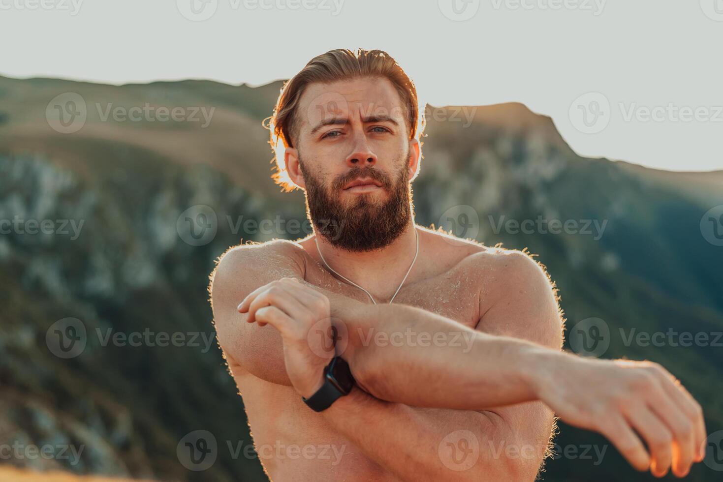 A man stretching his arms after a hard workout in the early hours of the morning photo