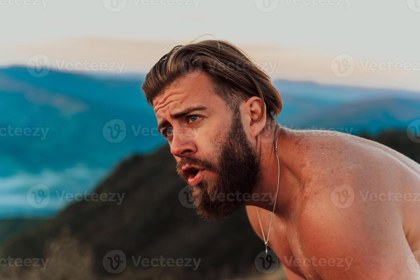 An athlete rests on top of a mountain after exhausting running training. photo