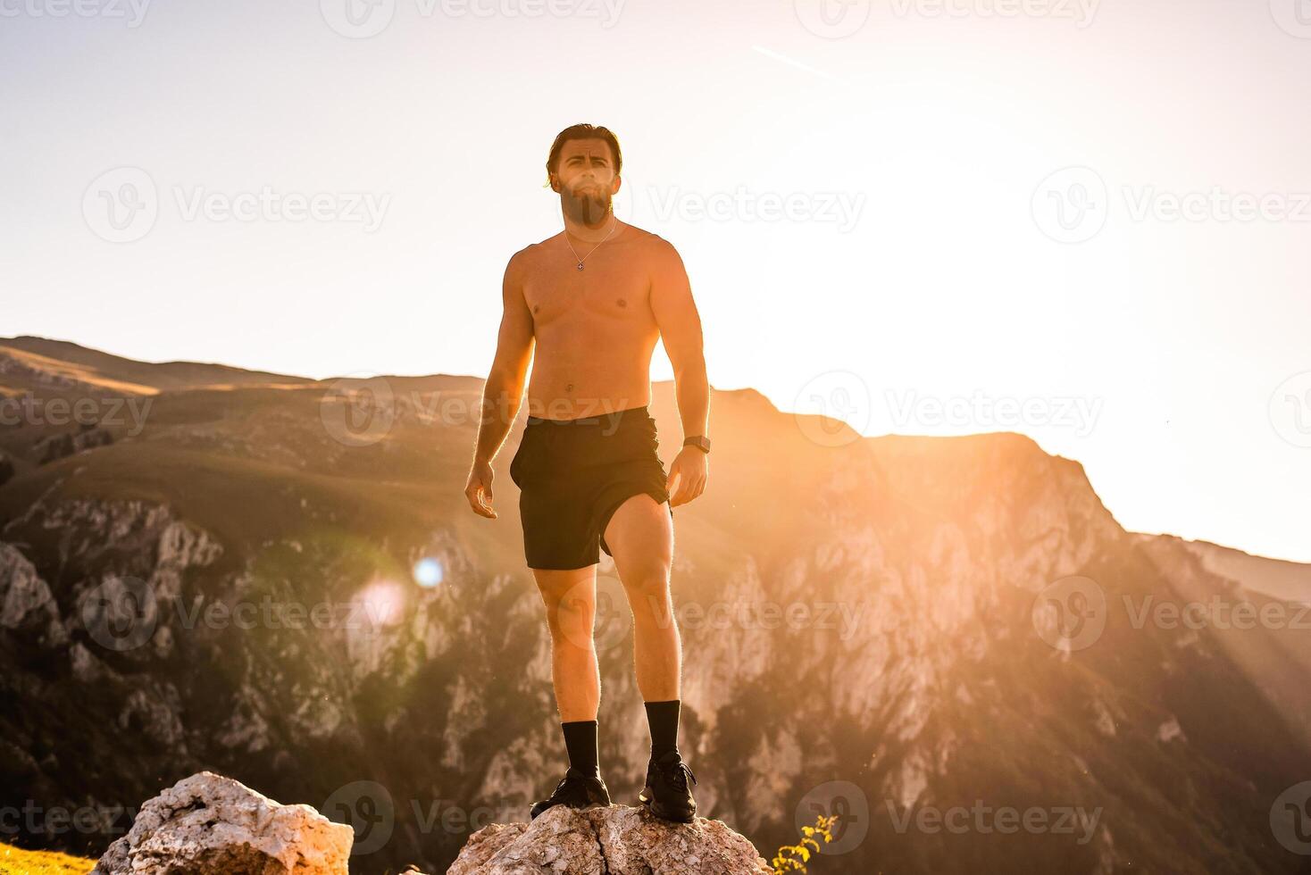 An athlete rests on top of a mountain after exhausting running training. photo