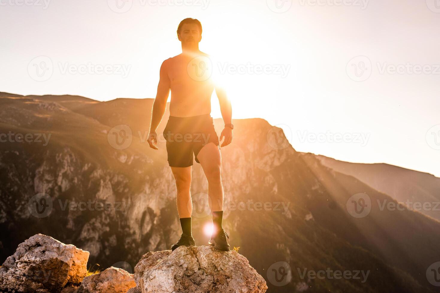 An athlete rests on top of a mountain after exhausting running training. photo