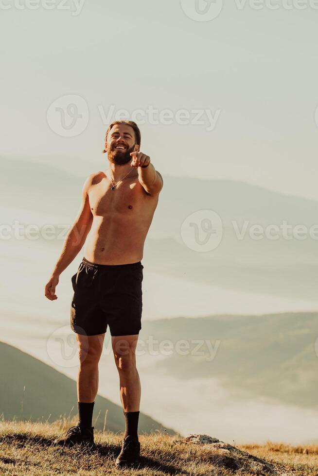 An athlete rests on top of a mountain after exhausting running training. photo