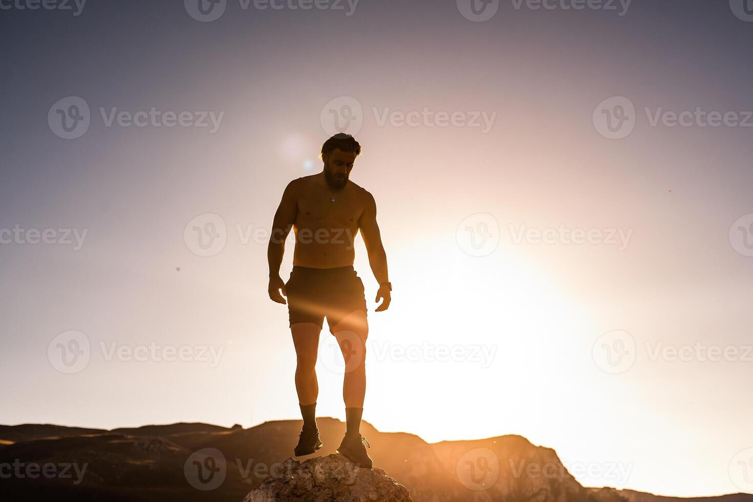 An athlete rests on top of a mountain after exhausting running training. photo