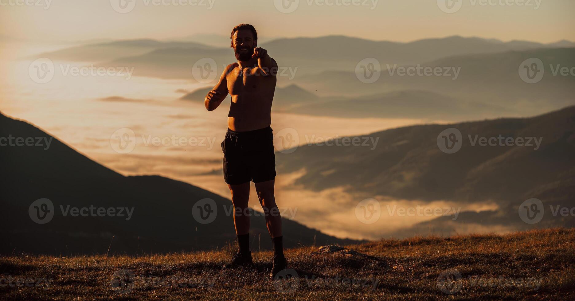 An athlete rests on top of a mountain after exhausting running training. photo