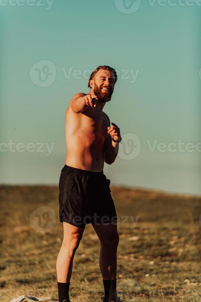 An athlete rests on top of a mountain after exhausting running training. photo