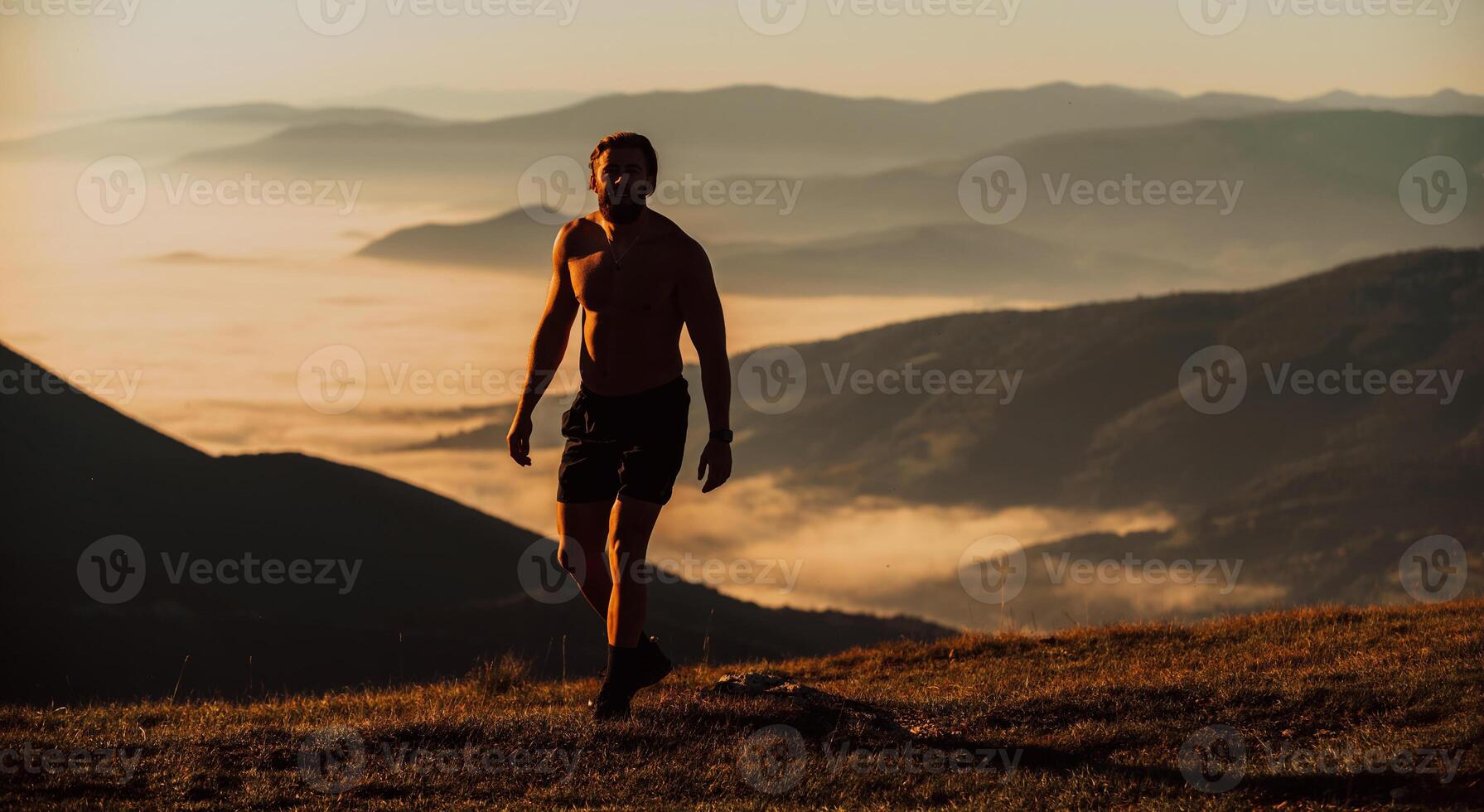 An athlete rests on top of a mountain after exhausting running training. photo