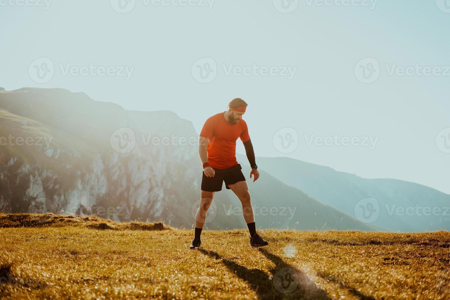 A determined athlete preparing for the start of training on the top of the mountain at sunrise. photo