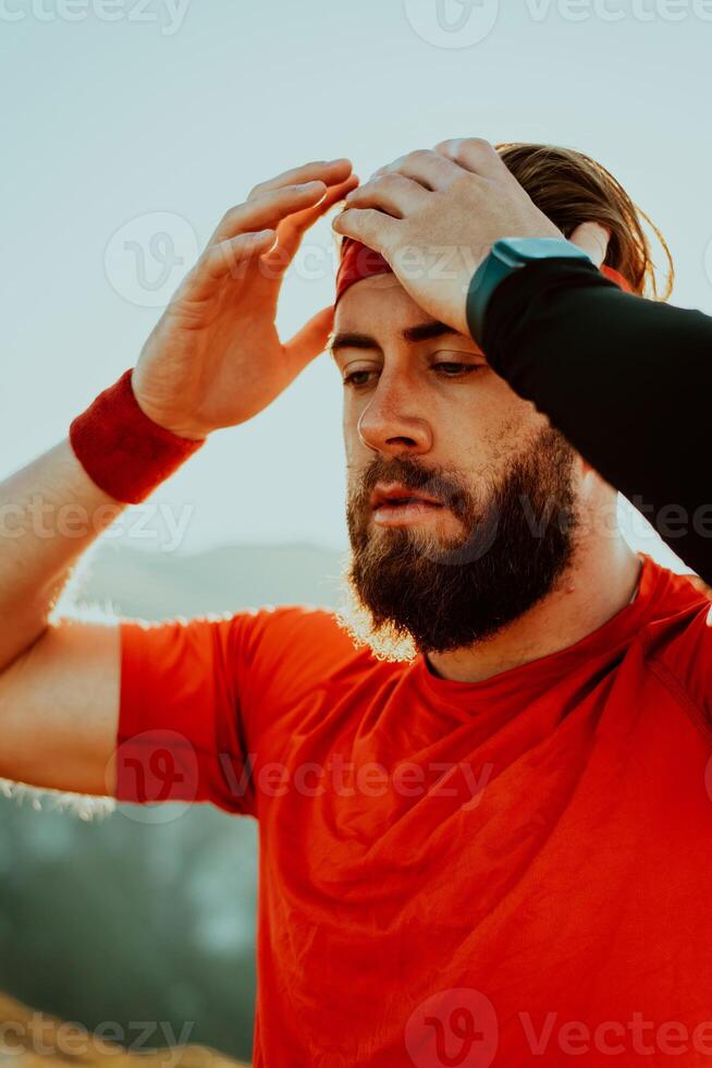 A determined athlete preparing for the start of training on the top of the mountain at sunrise. photo