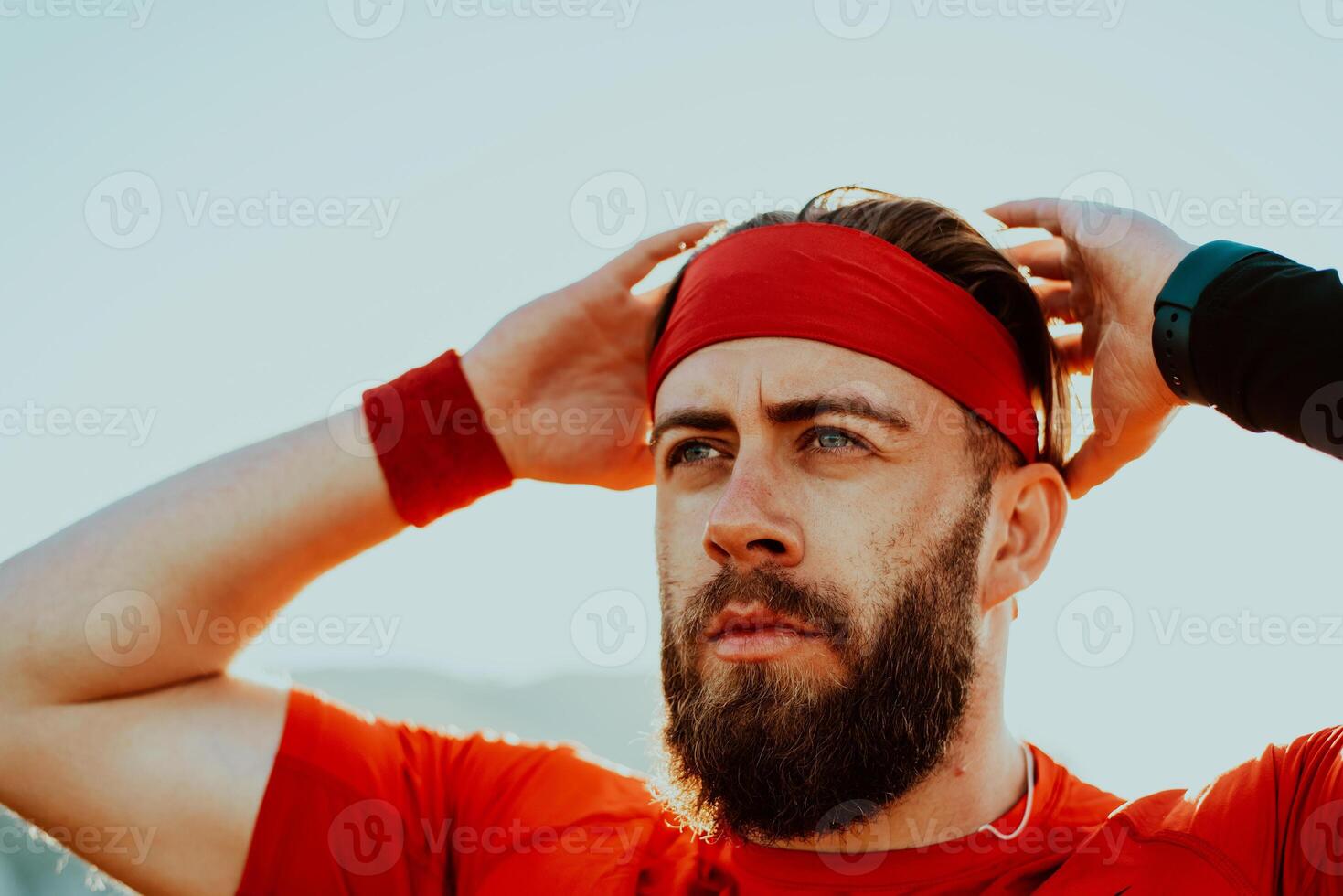 A determined athlete preparing for the start of training on the top of the mountain at sunrise. photo