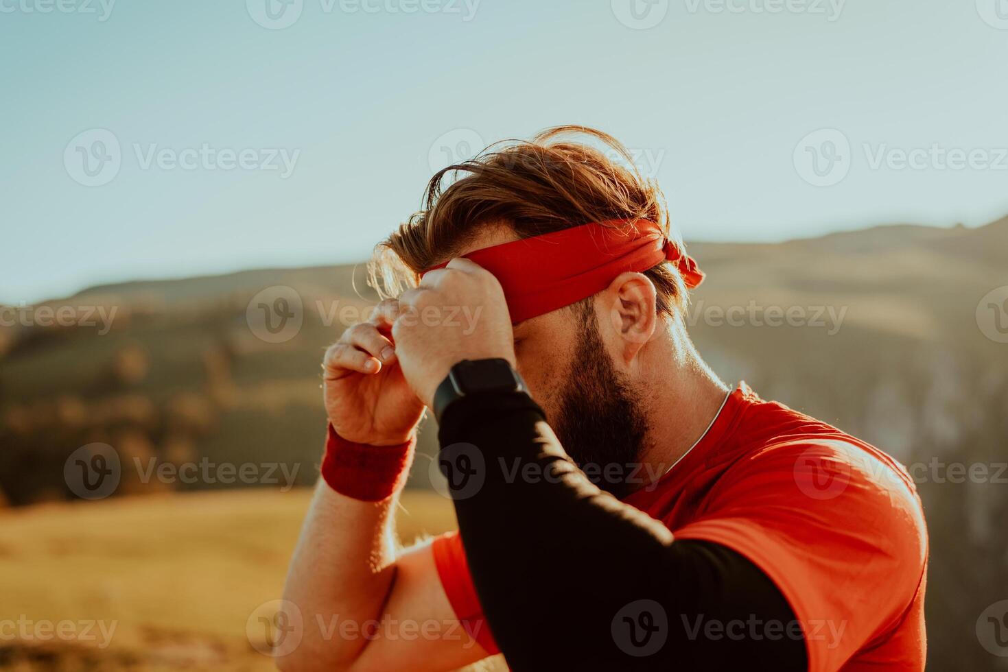 A determined athlete preparing for the start of training on the top of the mountain at sunrise. photo