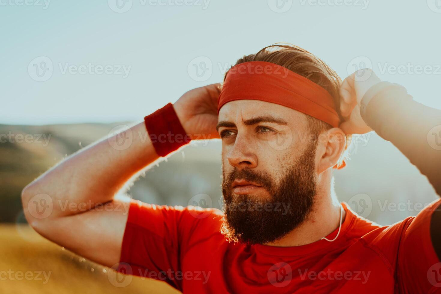 A determined athlete preparing for the start of training on the top of the mountain at sunrise. photo