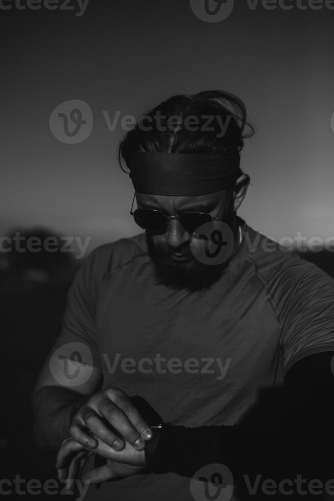 A determined athlete preparing for the start of training on the top of the mountain at sunrise. photo