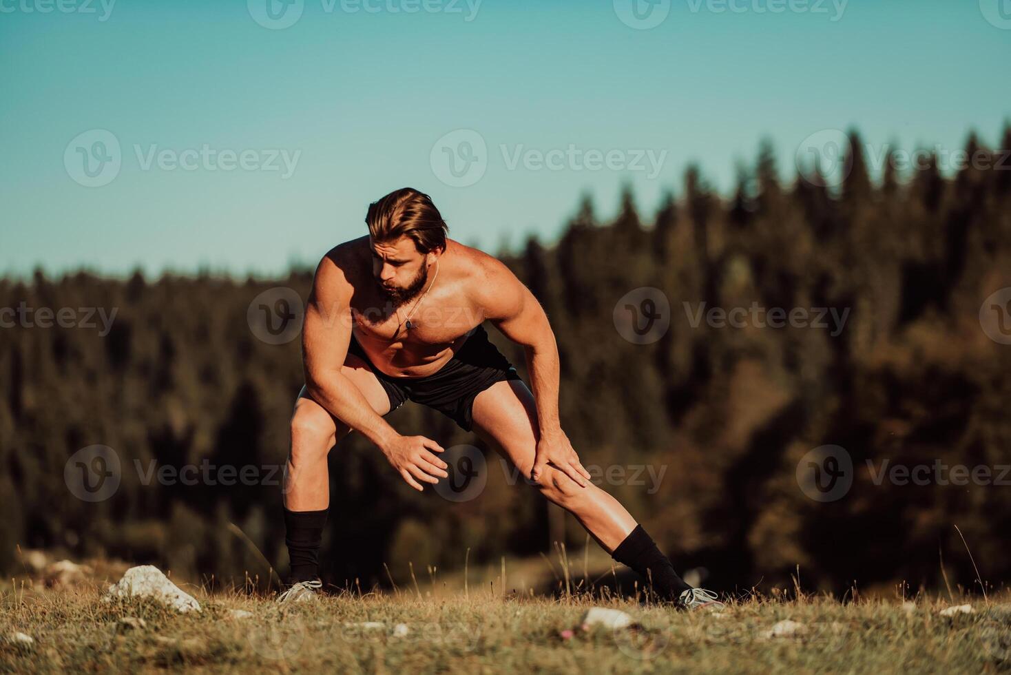 A man stretching after a hard workout in the early hours of the morning photo