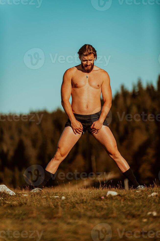 A man stretching after a hard workout in the early hours of the morning photo