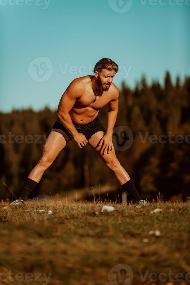 A man stretching after a hard workout in the early hours of the morning photo