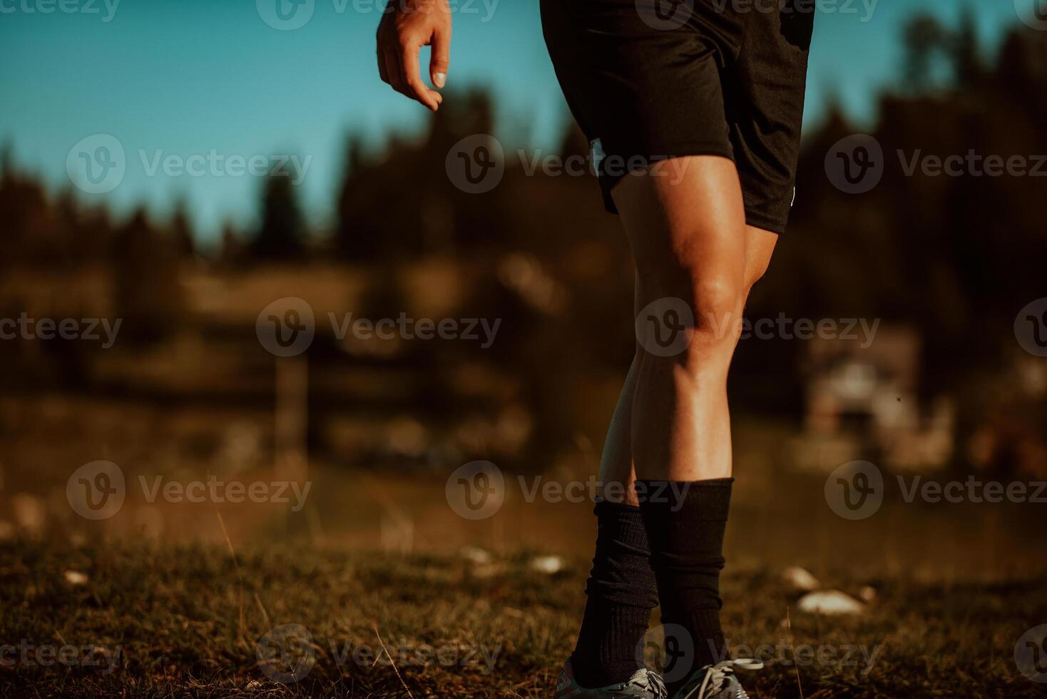 An athlete rests on top of a mountain after exhausting running training. photo