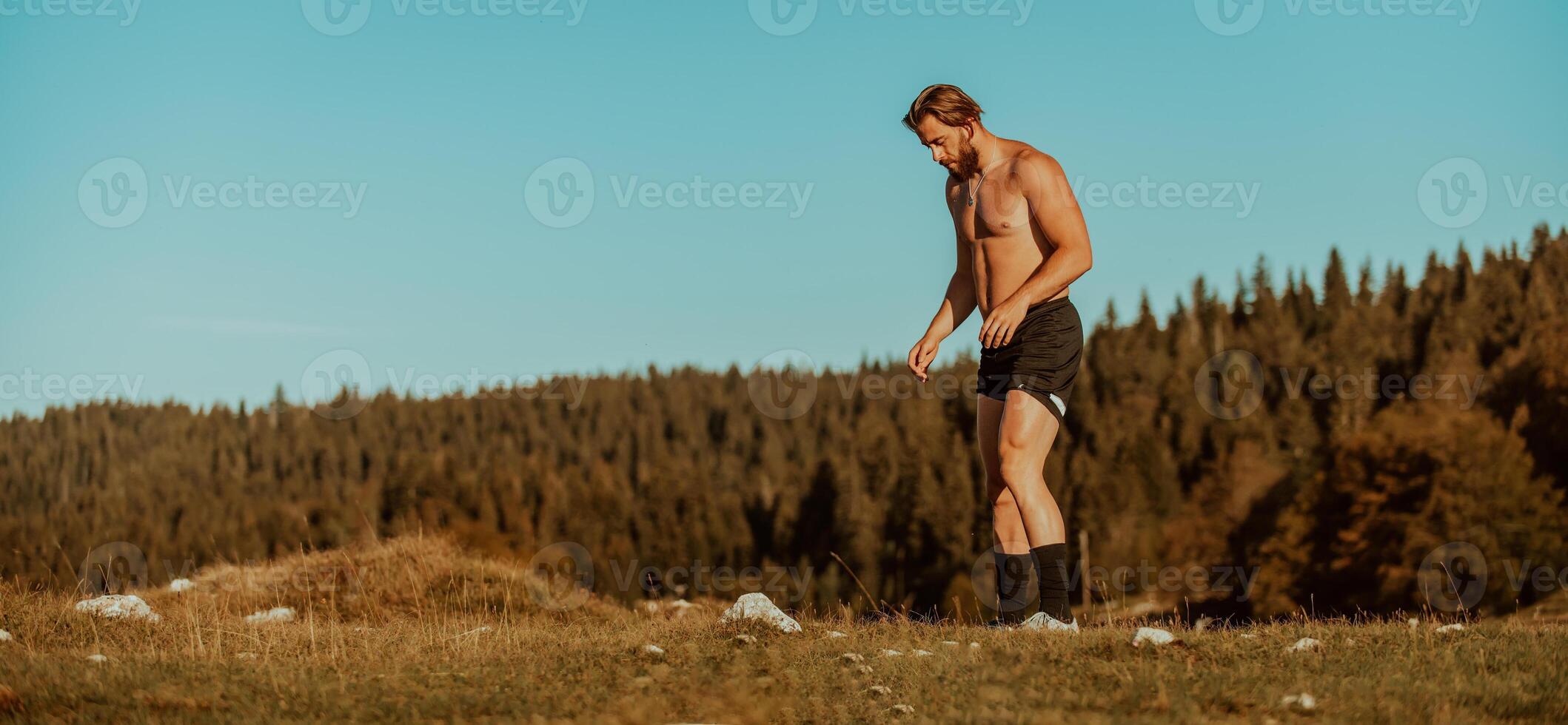An athlete rests on top of a mountain after exhausting running training. photo