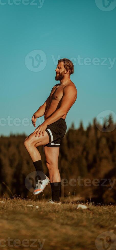 An athlete rests on top of a mountain after exhausting running training. photo