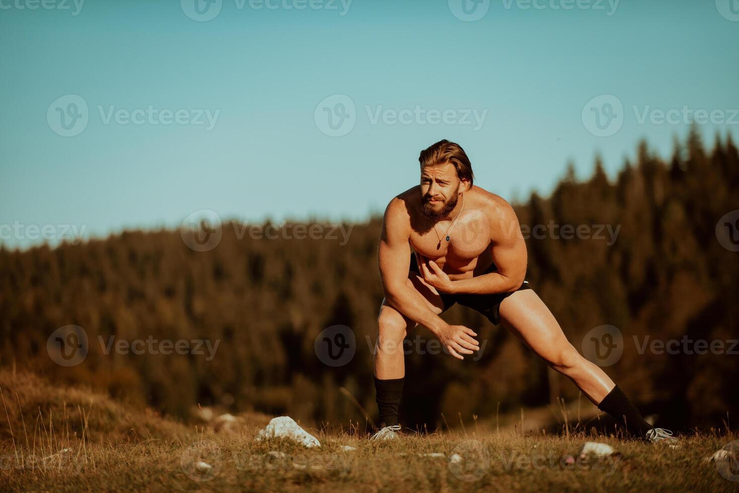 A man stretching after a hard workout in the early hours of the morning photo