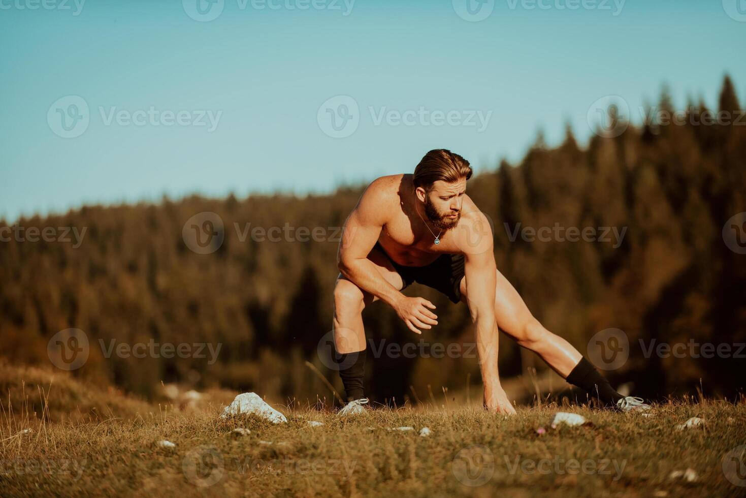 A man stretching after a hard workout in the early hours of the morning photo