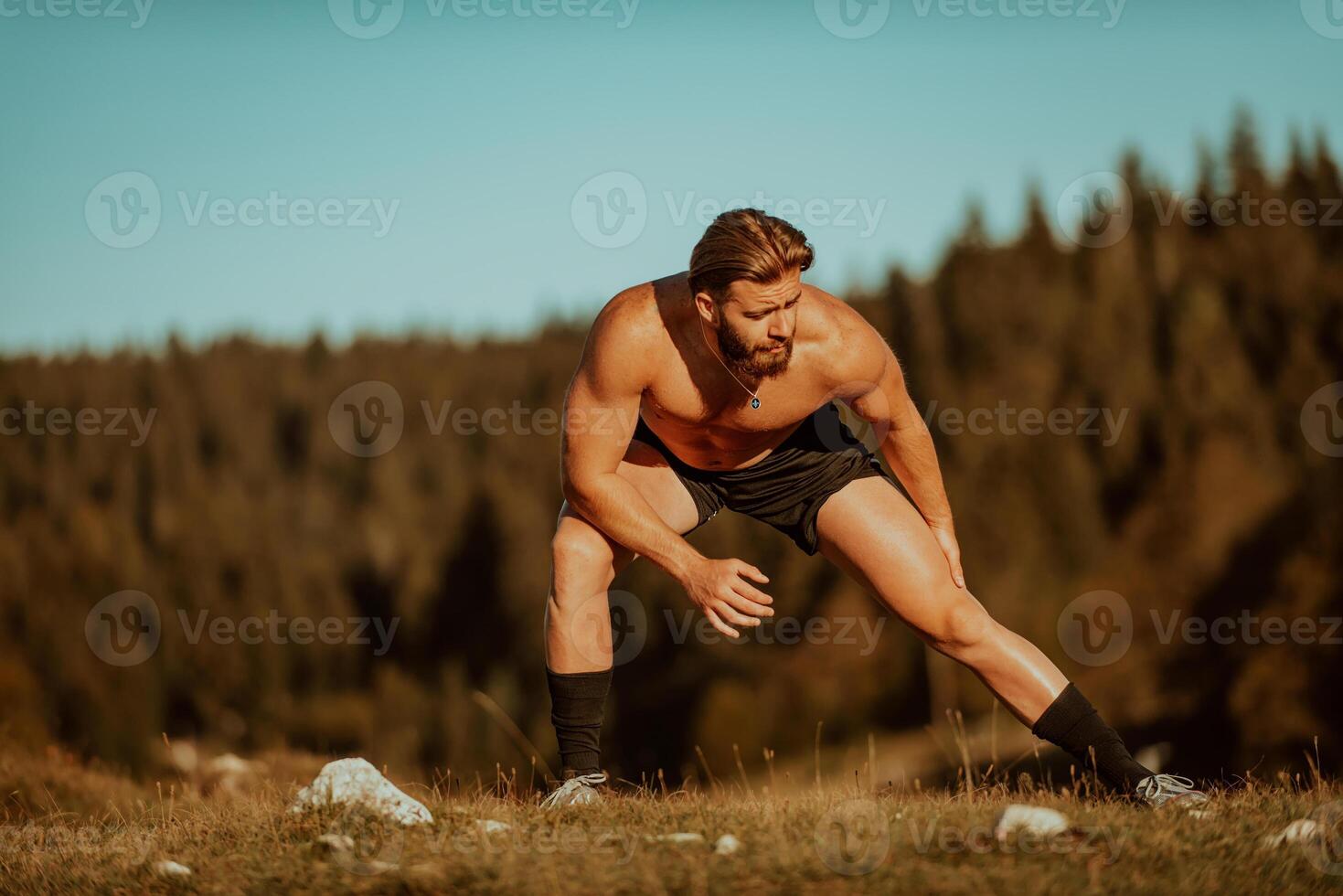A man stretching after a hard workout in the early hours of the morning photo