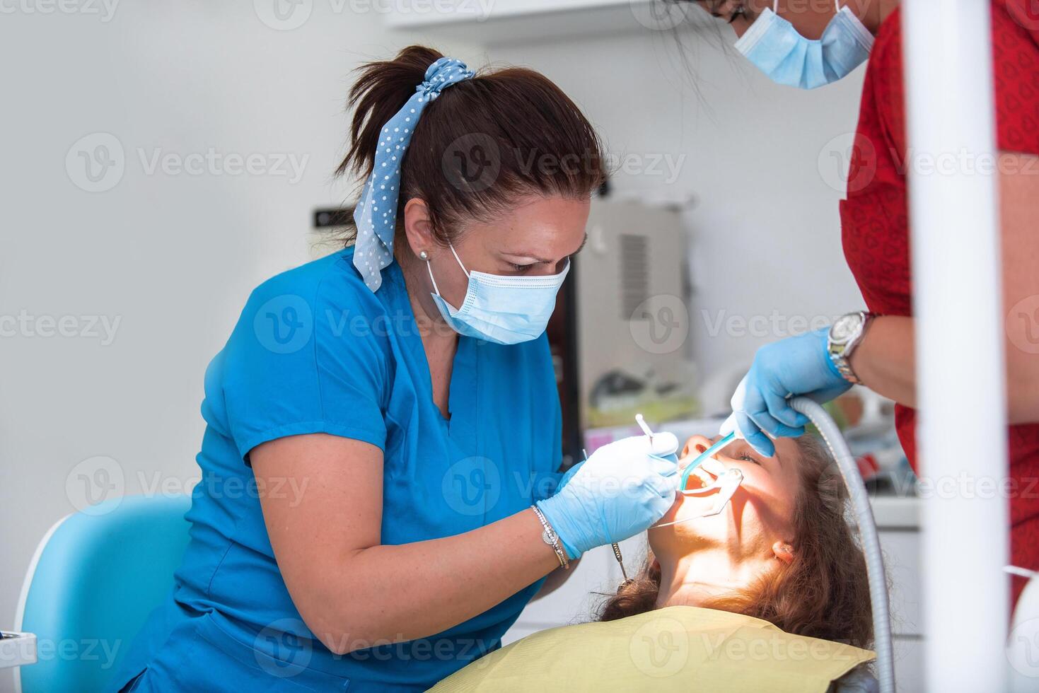 Dentist appointment at a dental clinic, placing braces locks on the teeth and pulling the archwire to fix it photo