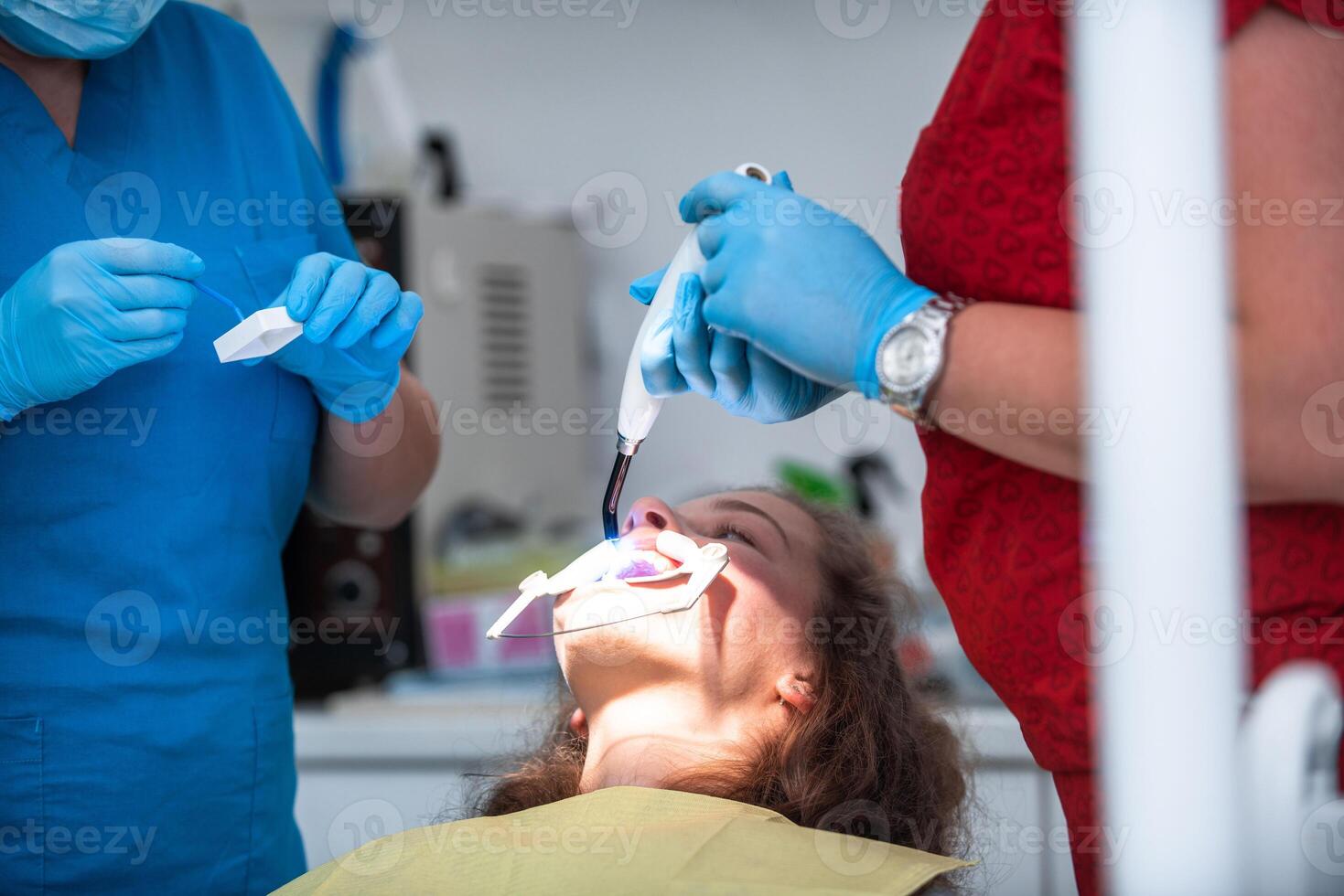 Dentist appointment at a dental clinic, placing braces locks on the teeth and pulling the archwire to fix it photo