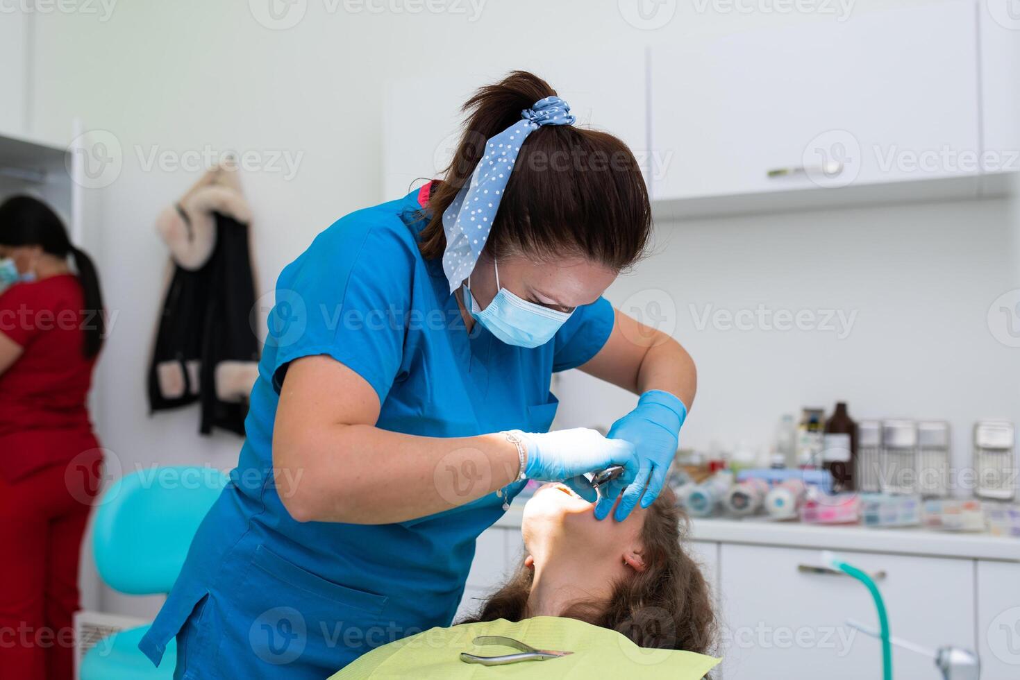 Dentist appointment at a dental clinic, placing braces locks on the teeth and pulling the archwire to fix it photo