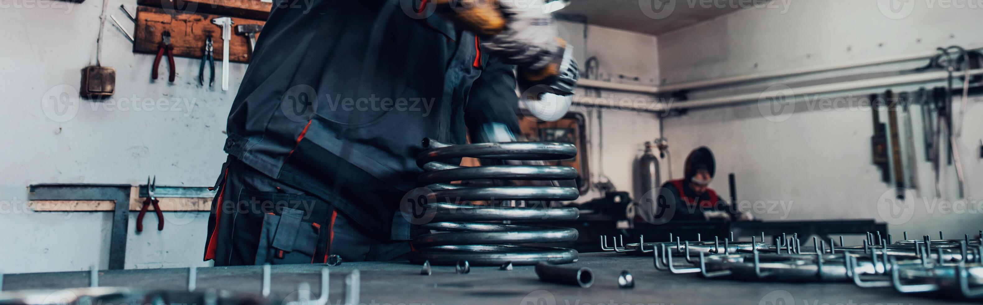 Locksmith in special clothes and goggles works in production. Metal processing with angle grinder. Sparks in metalworking. photo