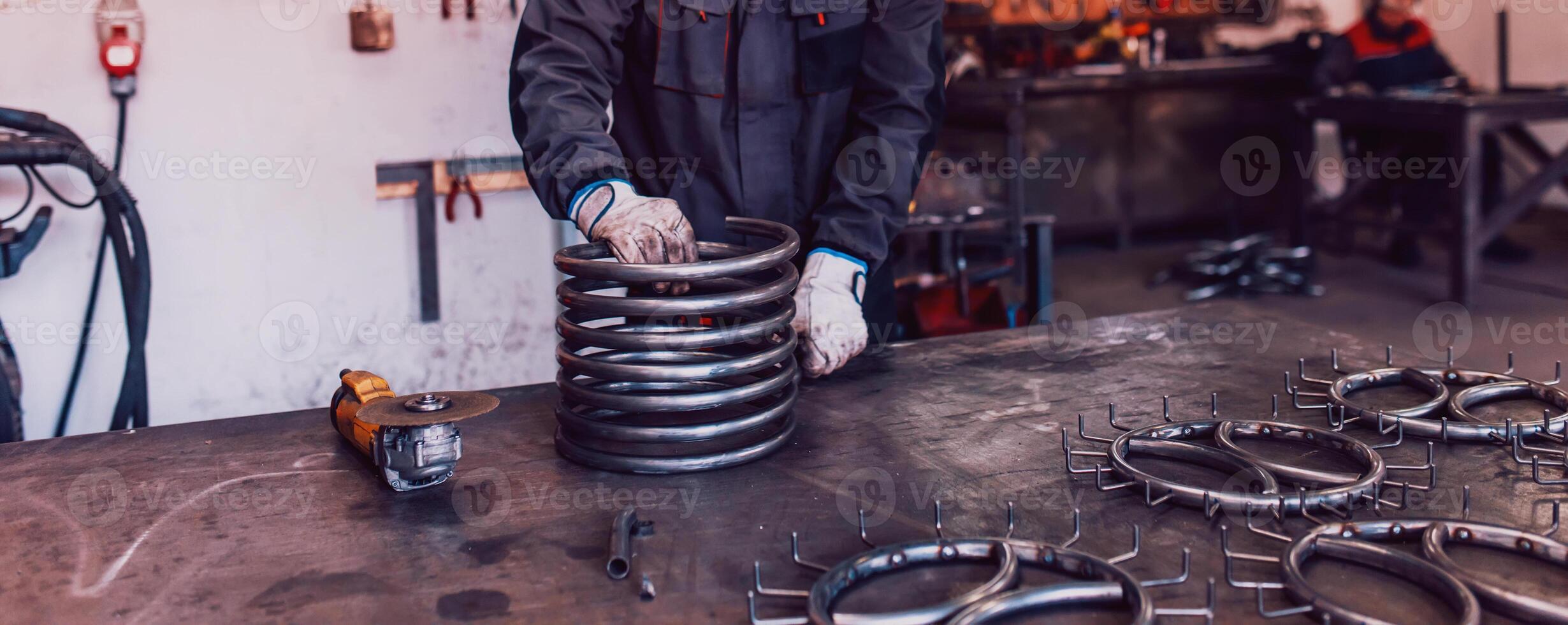 Locksmith in special clothes and goggles works in production. Metal processing with angle grinder. Sparks in metalworking. photo