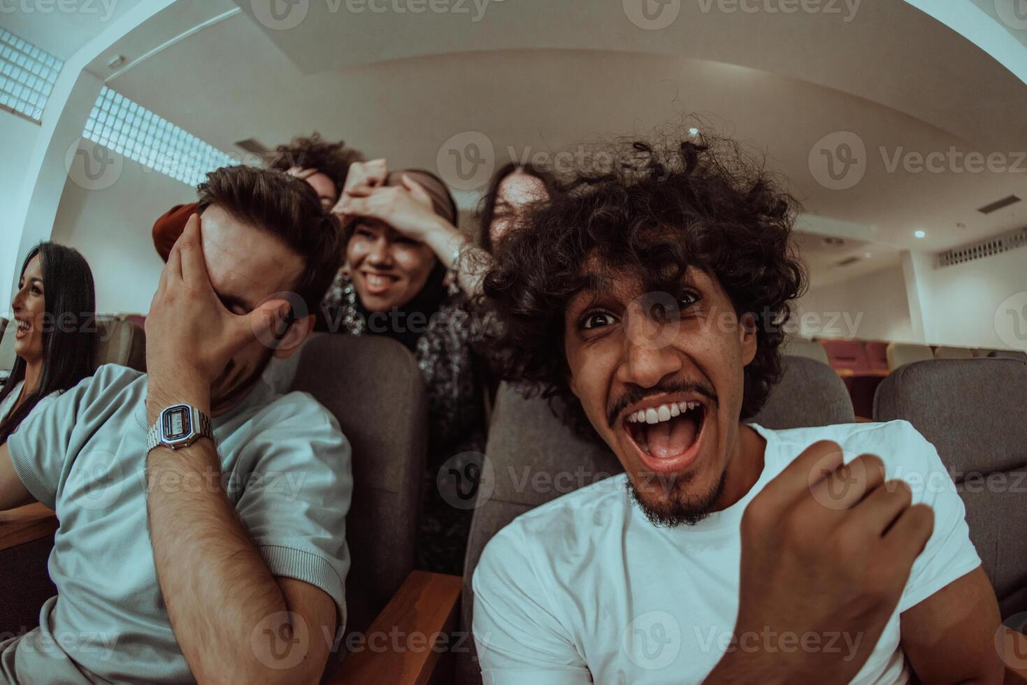 omedy film, with smiles oIn a cinema a diverse group of teenagers is gathered, watching a cn their faces, enjoying the shared laughter and the joy of being together. photo