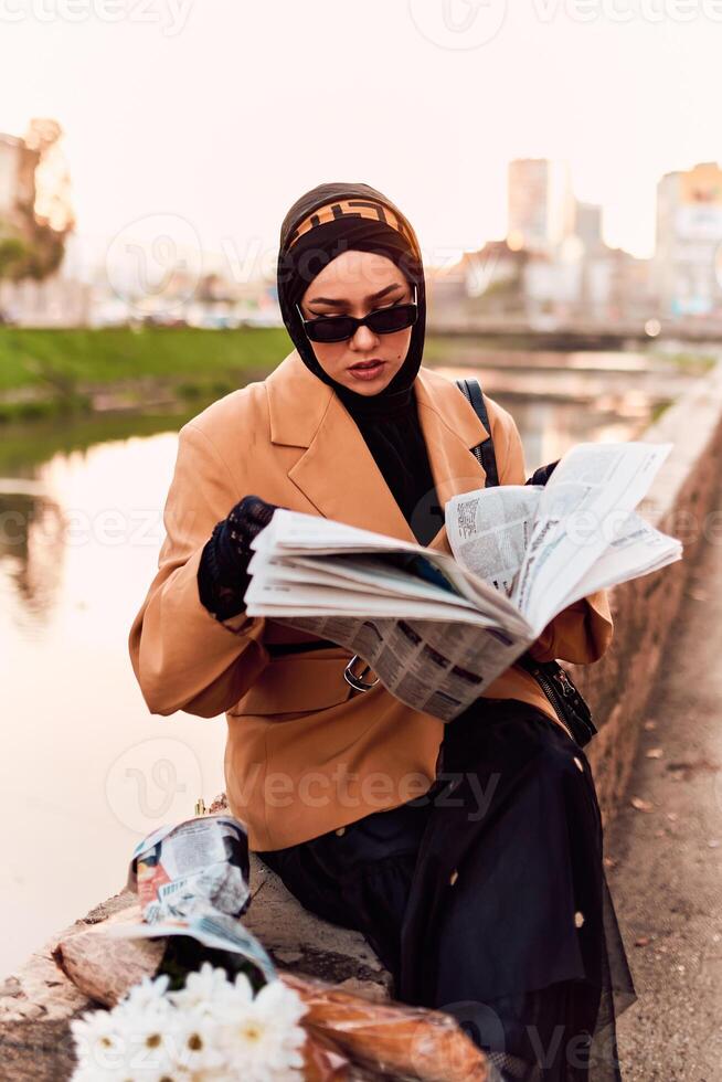 A woman in a hijab gracefully adorned in a fusion of old and modern French attire, immersed in the bustling streets of the city, engrossed in reading a newspaper photo