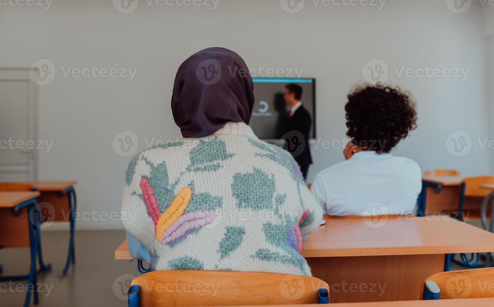 A diverse group of students is attentively listening, actively participating, and embracing modern education in a dynamic classroom setting, fostering collaboration and stimulating creativity. photo