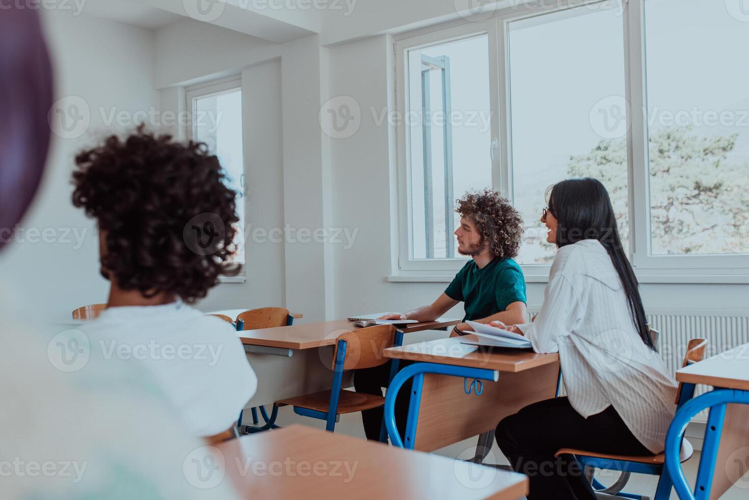 A group of diverse students engages in lively discussion as they educate themselves in a modern classroom, embracing the power of collaboration and knowledge exchange. photo