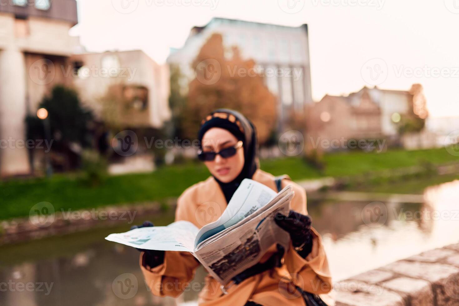 A woman in a hijab gracefully adorned in a fusion of old and modern French attire, immersed in the bustling streets of the city, engrossed in reading a newspaper photo
