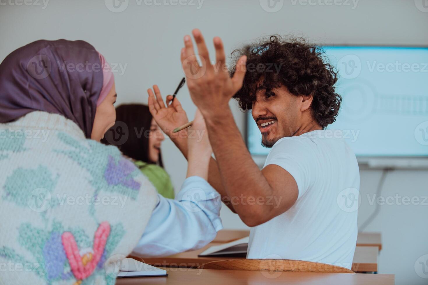 In a classroom setting an African American man engaged in a heated argument with his Muslim woman friend wearing a hijab, highlighting a moment of intense discussion and cultural diversity photo
