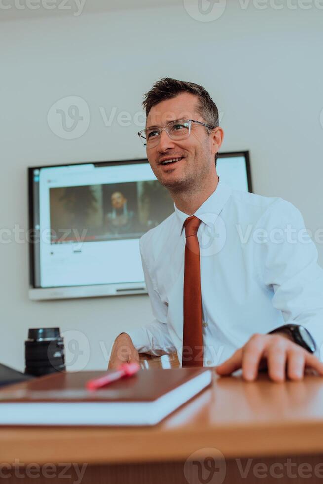 A modernly dressed professor engages in educating students, who listen attentively, creating a dynamic scene of knowledge-sharing and focused learning in the classroom. photo