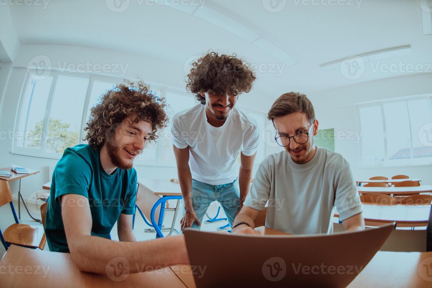 A diverse studetns group, including an Afro American with an afro hairstyle communicating and engage with their colleague while seated in a modern classroom, collectively focused on a laptop. photo